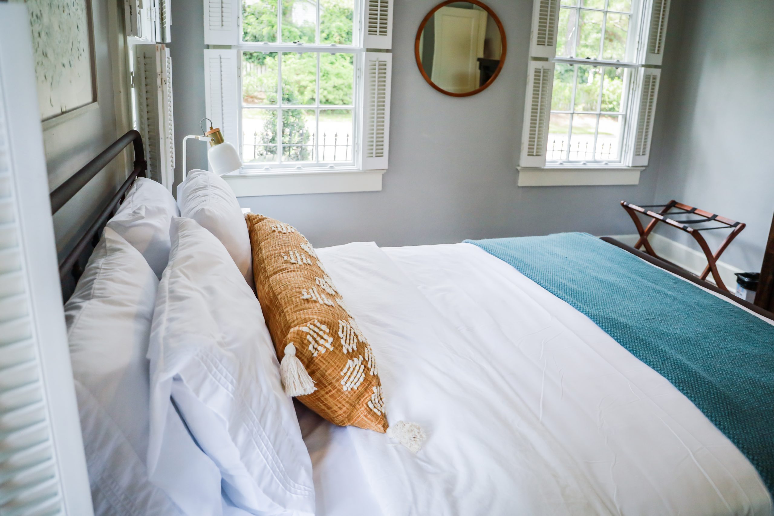 A guest bedroom with a queen sized bed and nightstand at a short term rental small cottage style house.